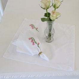 vacker vit tygservett med rosa brodyr blomklocka
