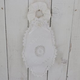 gårdsromantisk toalettrullehållare i tyg med vita handvirkade detaljer.