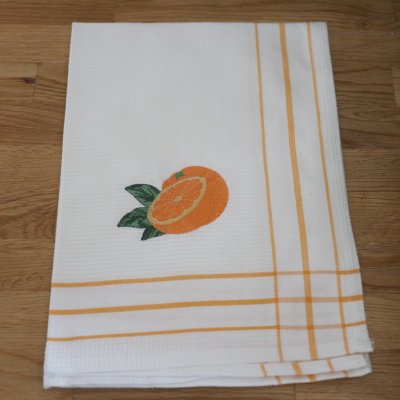 vit våfflad kökshandduk med svensk design broderad apelsin som motiv i lantlig bond stil